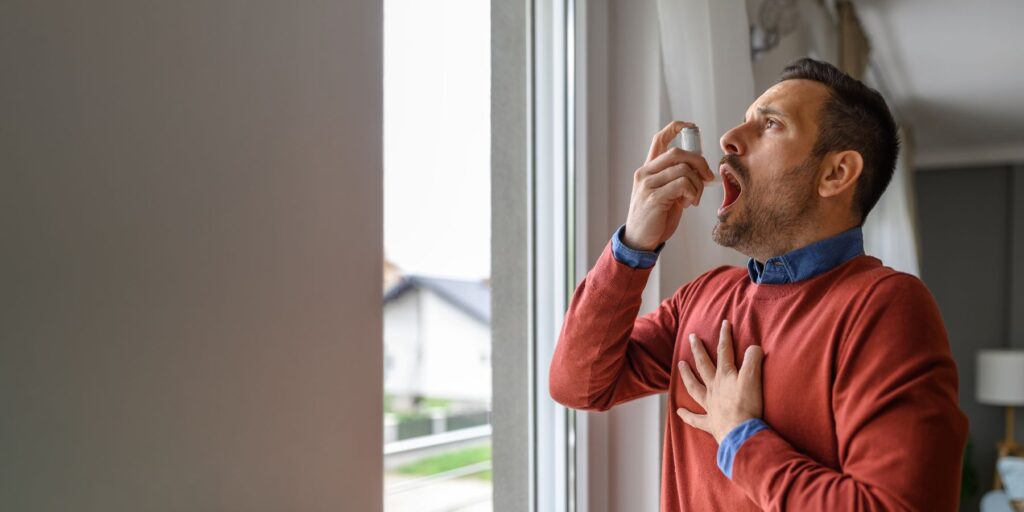 hombre utilizando inhalador para prevenir broncoespasmos frecuentes.